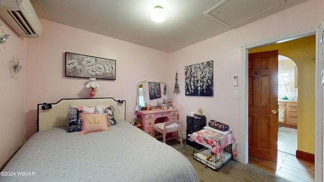 bedroom featuring a wall mounted air conditioner and hardwood / wood-style flooring