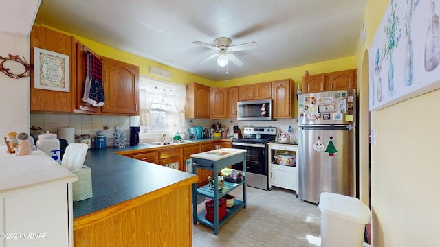 kitchen featuring decorative backsplash, ceiling fan, sink, and stainless steel appliances