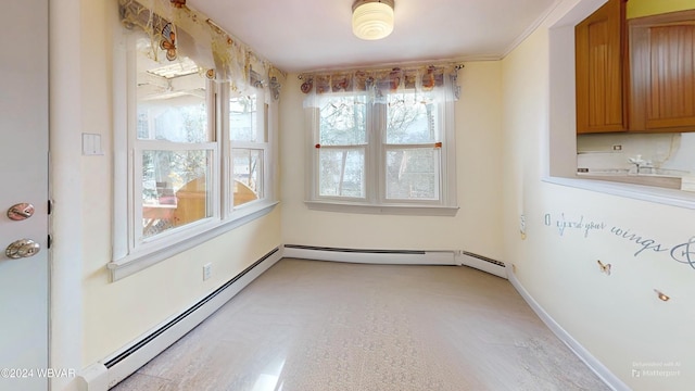 unfurnished dining area featuring crown molding and a baseboard heating unit