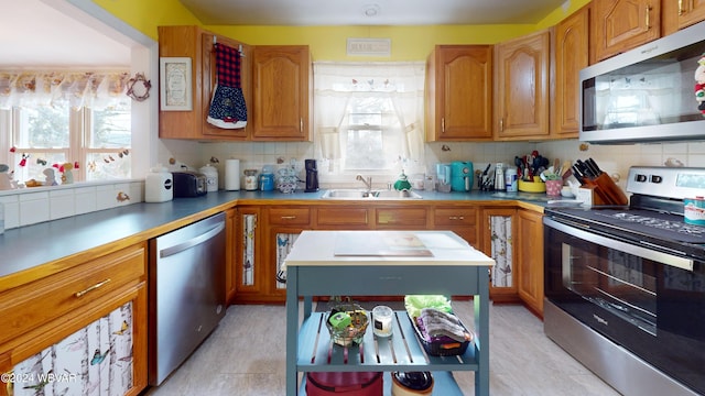 kitchen featuring tasteful backsplash, sink, and appliances with stainless steel finishes