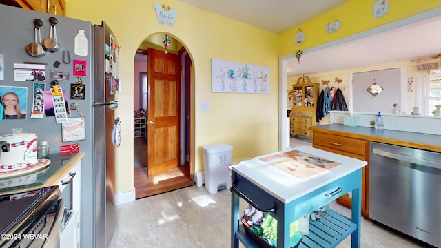 kitchen with appliances with stainless steel finishes and light hardwood / wood-style floors