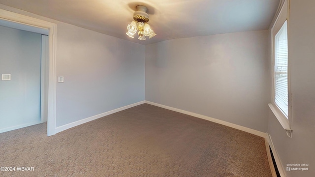 carpeted empty room with a chandelier and a baseboard radiator