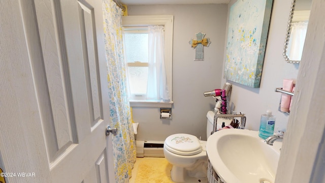 bathroom featuring toilet, a baseboard heating unit, and sink