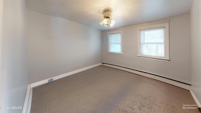 carpeted empty room with a baseboard radiator