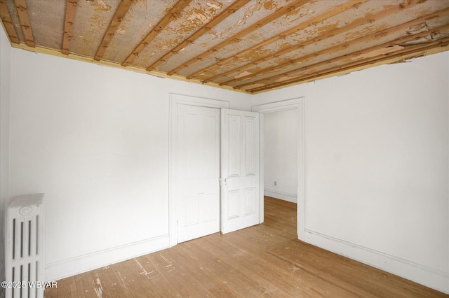 330 High St, Williamsport, PA 17701 - unfurnished bedroom with radiator, wood finished floors, and baseboards