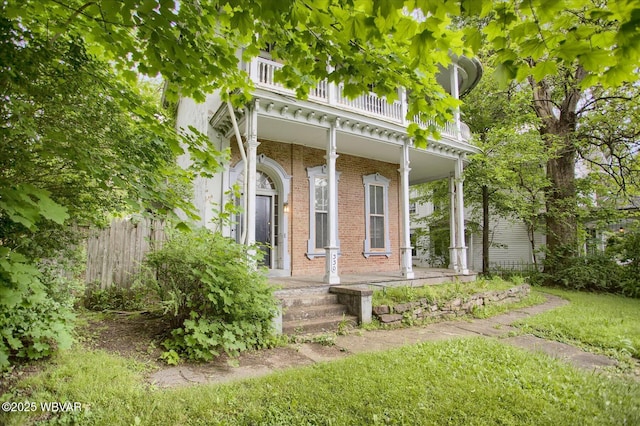 330 High St, Williamsport, PA 17701 - view of exterior entry with covered porch, brick siding, and a balcony