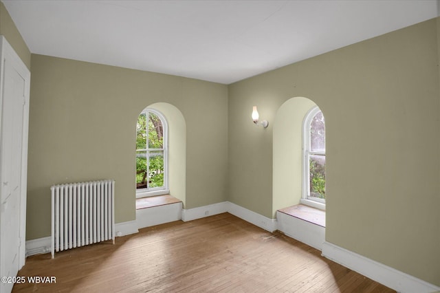 330 High St, Williamsport, PA 17701 - unfurnished room featuring radiator, wood-type flooring, plenty of natural light, and arched walkways