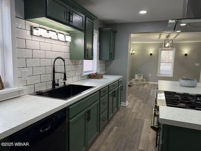 kitchen featuring dishwasher, decorative light fixtures, dark wood-type flooring, sink, and plenty of natural light