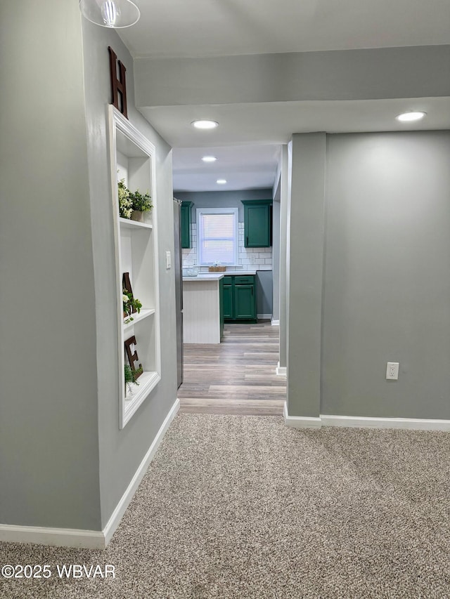 hall featuring light carpet and built in features