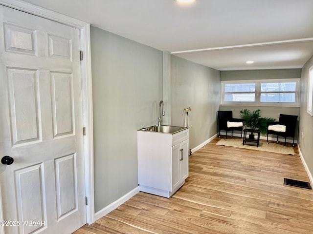 laundry room with sink and light hardwood / wood-style flooring