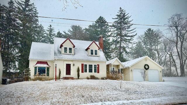 new england style home featuring a garage and a chimney