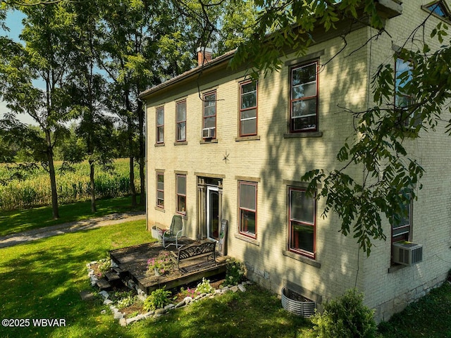 view of side of home featuring cooling unit, central AC unit, and a yard