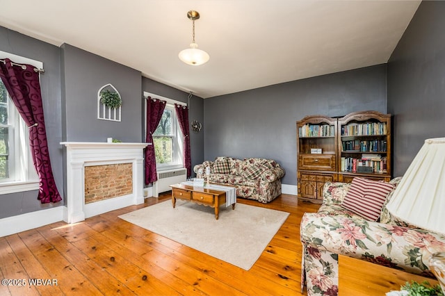 living room with hardwood / wood-style floors, radiator heating unit, and plenty of natural light