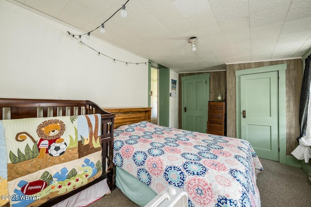 carpeted bedroom with wooden walls