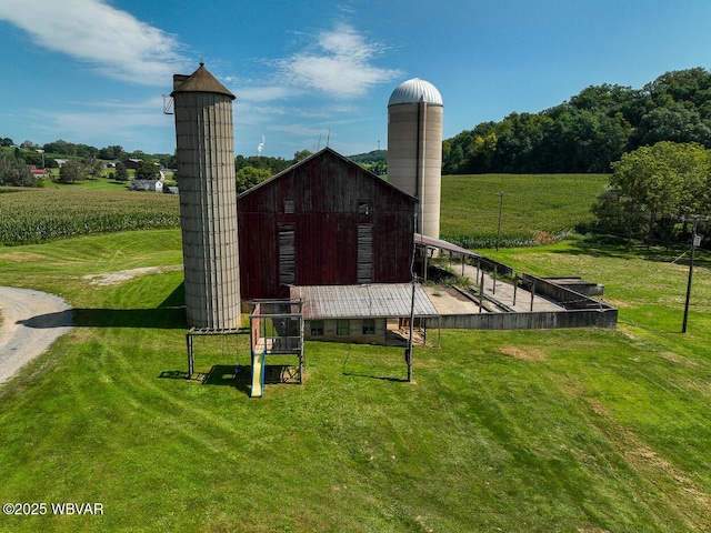 exterior space with an outdoor structure, a rural view, and a lawn