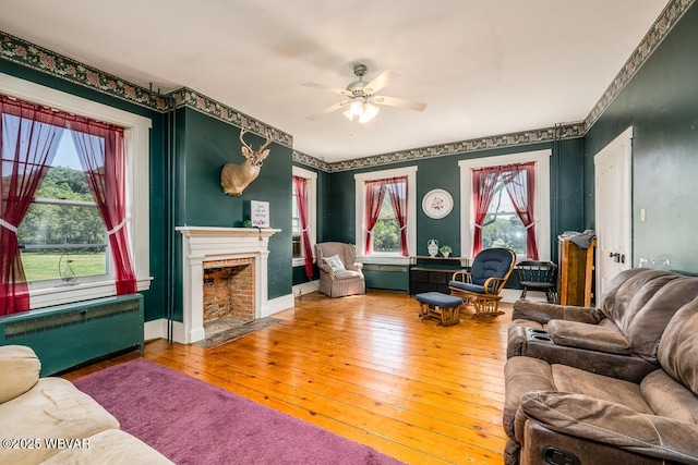 living room featuring wood-type flooring, radiator, and ceiling fan