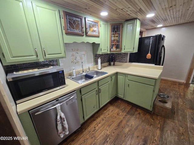 kitchen featuring a sink, stainless steel appliances, green cabinetry, dark wood-style flooring, and tasteful backsplash