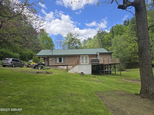 rear view of house featuring a wooden deck, a lawn, and a chimney