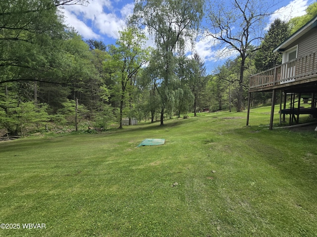 view of grassy yard featuring a wooden deck