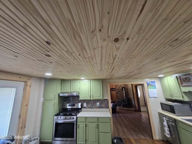 kitchen featuring green cabinets, appliances with stainless steel finishes, wooden ceiling, under cabinet range hood, and a wood stove