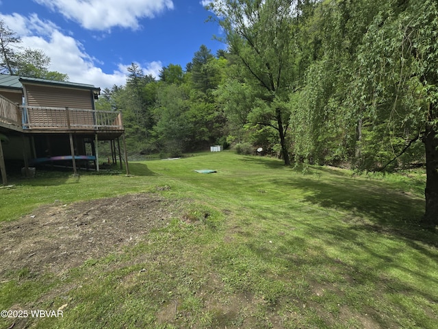 view of green lawn featuring a deck