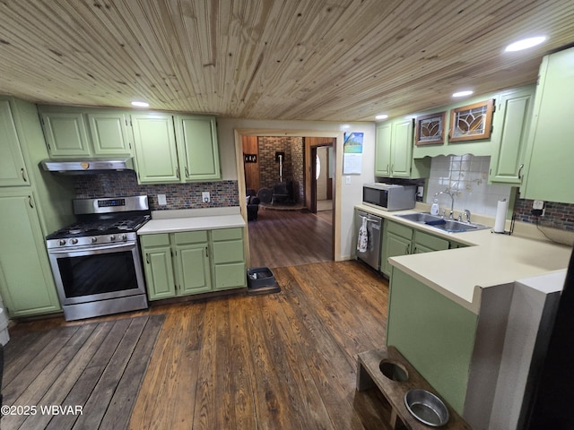 kitchen featuring green cabinetry, appliances with stainless steel finishes, a sink, under cabinet range hood, and light countertops
