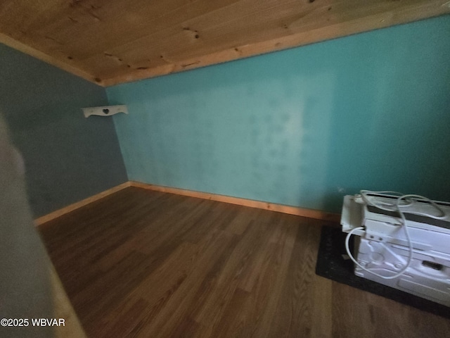 unfurnished room with wood finished floors, vaulted ceiling, wood ceiling, and baseboards