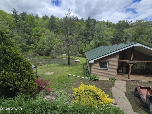 view of grassy yard featuring a view of trees