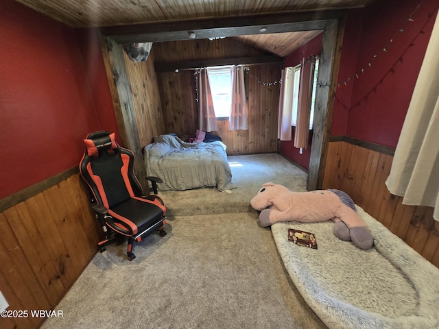 carpeted bedroom featuring wooden walls, wooden ceiling, and wainscoting