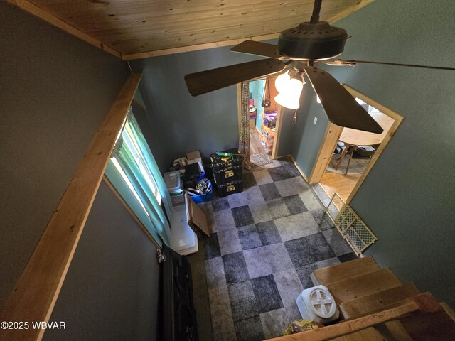 living area with a ceiling fan and wooden ceiling