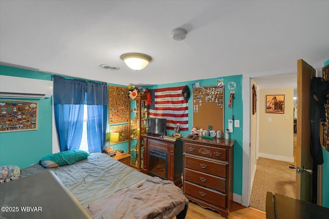 522 S Main St, Jersey Shore, PA 17740 - bedroom featuring light wood-style flooring, an AC wall unit, and baseboards