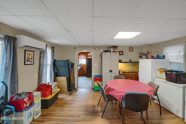 522 S Main St, Jersey Shore, PA 17740 - dining area with a wall unit AC, wood finished floors, arched walkways, and a drop ceiling
