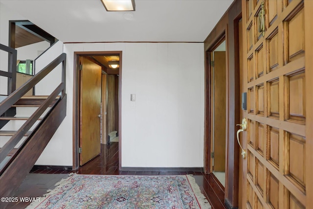 hallway featuring baseboards and stairs