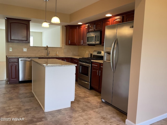 kitchen featuring appliances with stainless steel finishes, backsplash, sink, pendant lighting, and a kitchen island