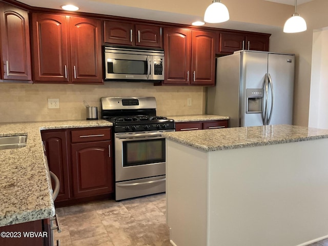 kitchen featuring pendant lighting, appliances with stainless steel finishes, tasteful backsplash, a kitchen island, and light stone counters