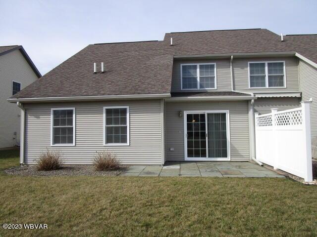 rear view of property featuring a yard and a patio area