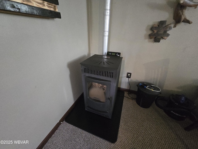 detailed view of a wood stove, baseboards, and carpet flooring