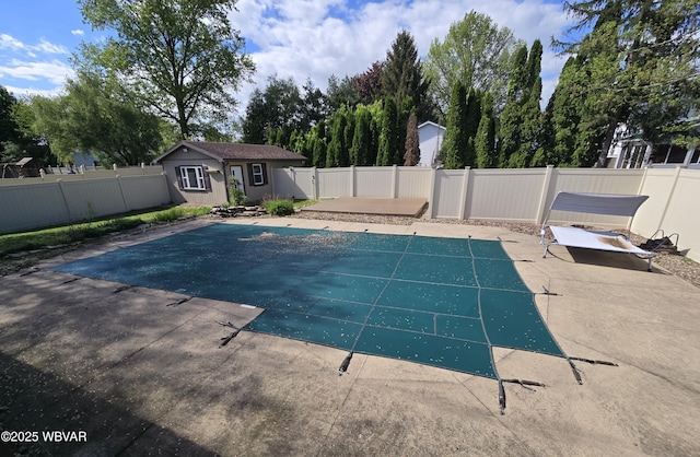 view of swimming pool with a patio area, a fenced backyard, and an outbuilding