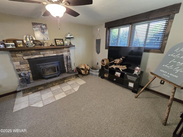 carpeted living area with a wood stove and a ceiling fan