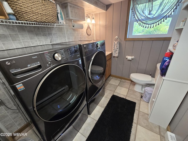 laundry room featuring independent washer and dryer, light tile patterned floors, and baseboards