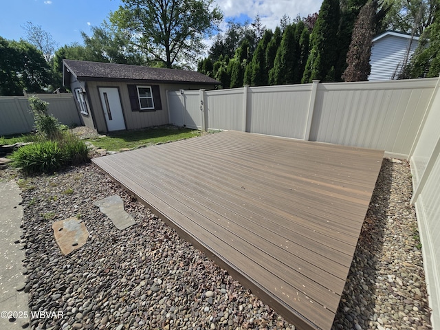 wooden terrace featuring a fenced backyard and an outdoor structure