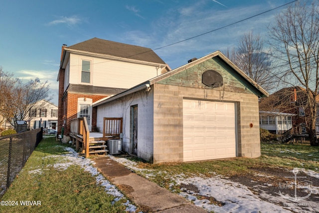 exterior space with central AC and a garage