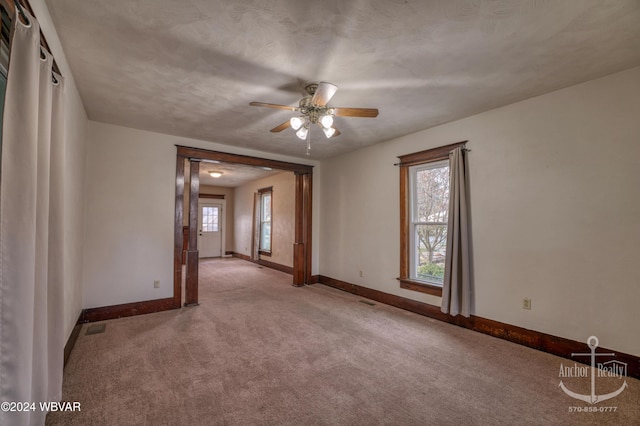 unfurnished room with ceiling fan and light colored carpet