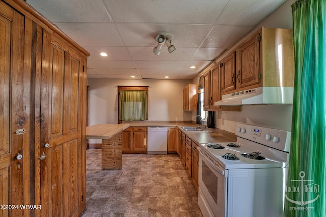 kitchen featuring a paneled ceiling, sink, and white appliances