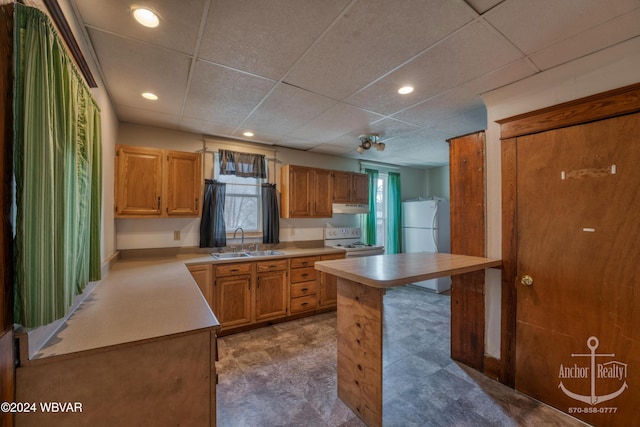 kitchen with a paneled ceiling, sink, and white appliances