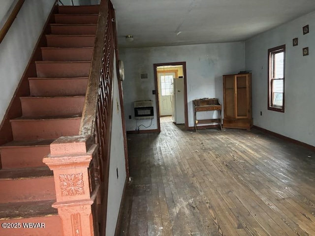 interior space featuring wood-type flooring, baseboards, and heating unit