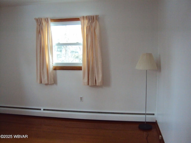 unfurnished room featuring a baseboard heating unit