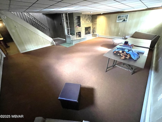 carpeted living room featuring a drop ceiling, a fireplace, and baseboard heating