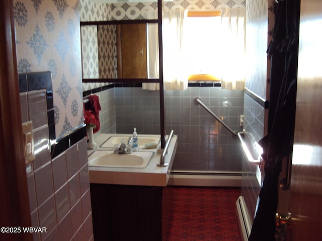 bathroom featuring tile walls, vanity, and baseboard heating