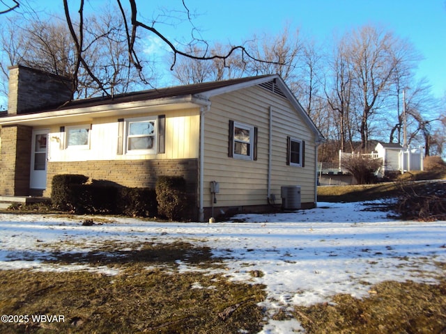 snow covered property featuring central air condition unit